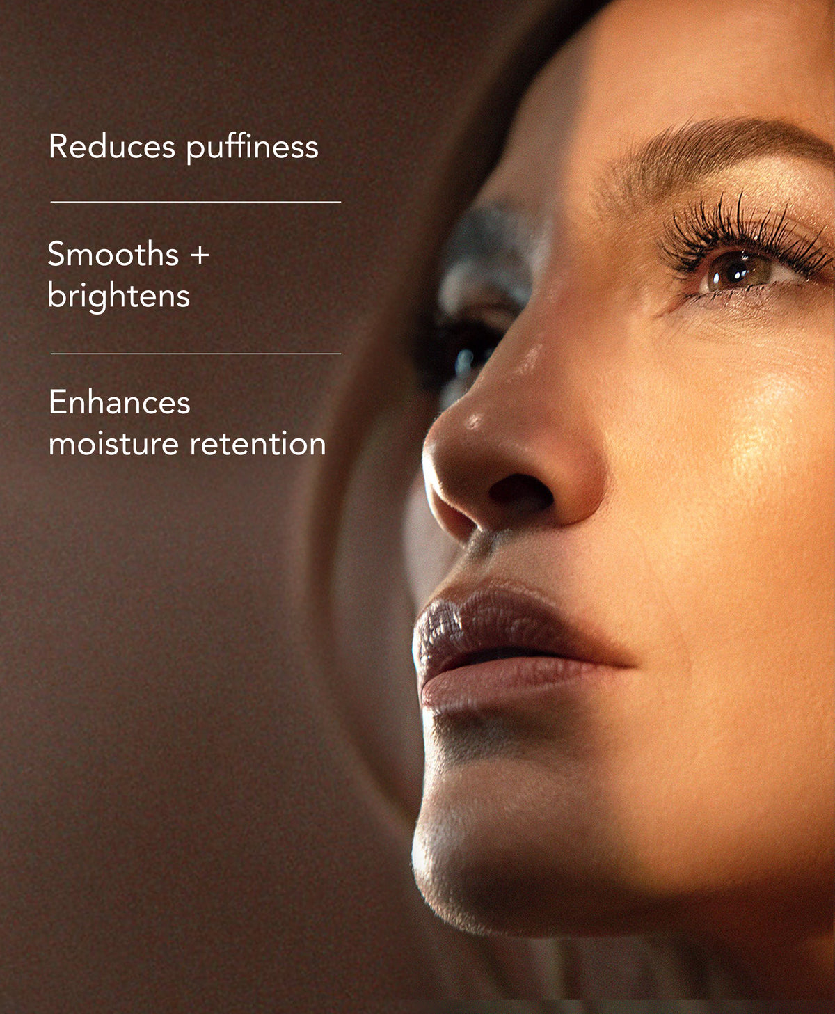 Close-up of a woman's face with text on the left reading 'Reduces puffiness', 'Smooths + brightens', and 'Enhances moisture retention' 
