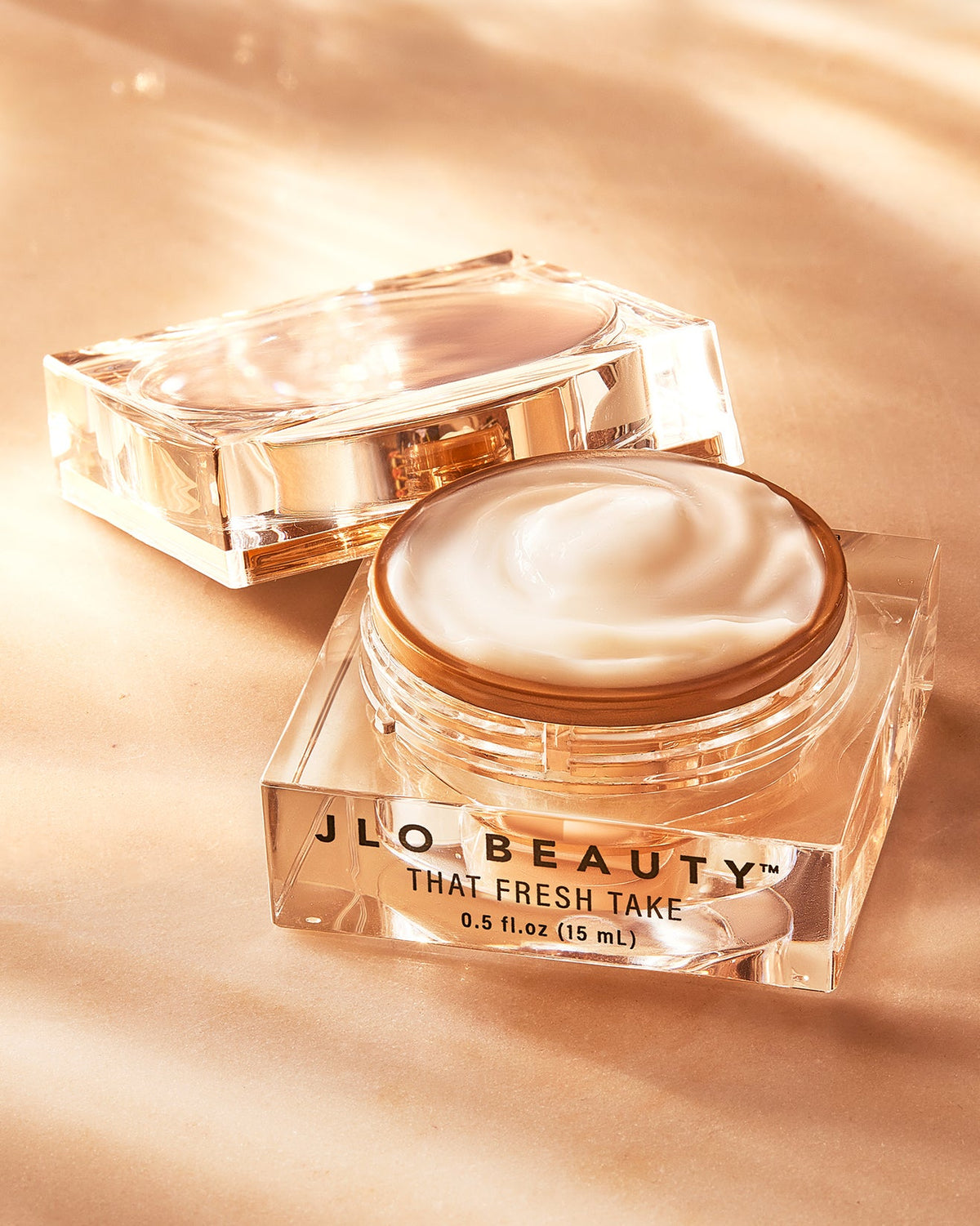 Open Eye Cream jar arranged on a warm gold backdrop.
