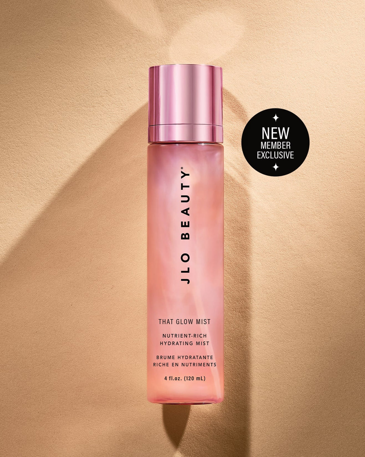 JLO Beauty Glow Mist bottle in soft pink on a neutral background. With badge on top right saying NEW MEMBER exclusive