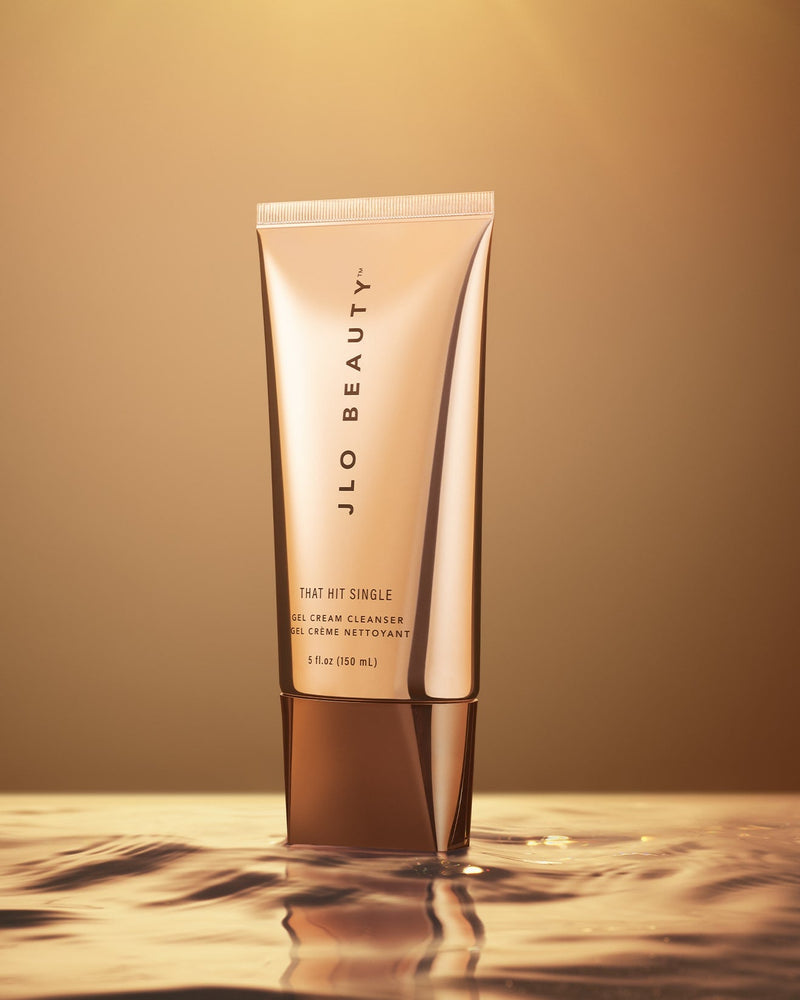 JLO Beauty That Hit Single Gel Cream Cleanser tube in a metallic rose gold finish.