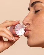 A picture of a woman kissing JLO Beauty skincare.