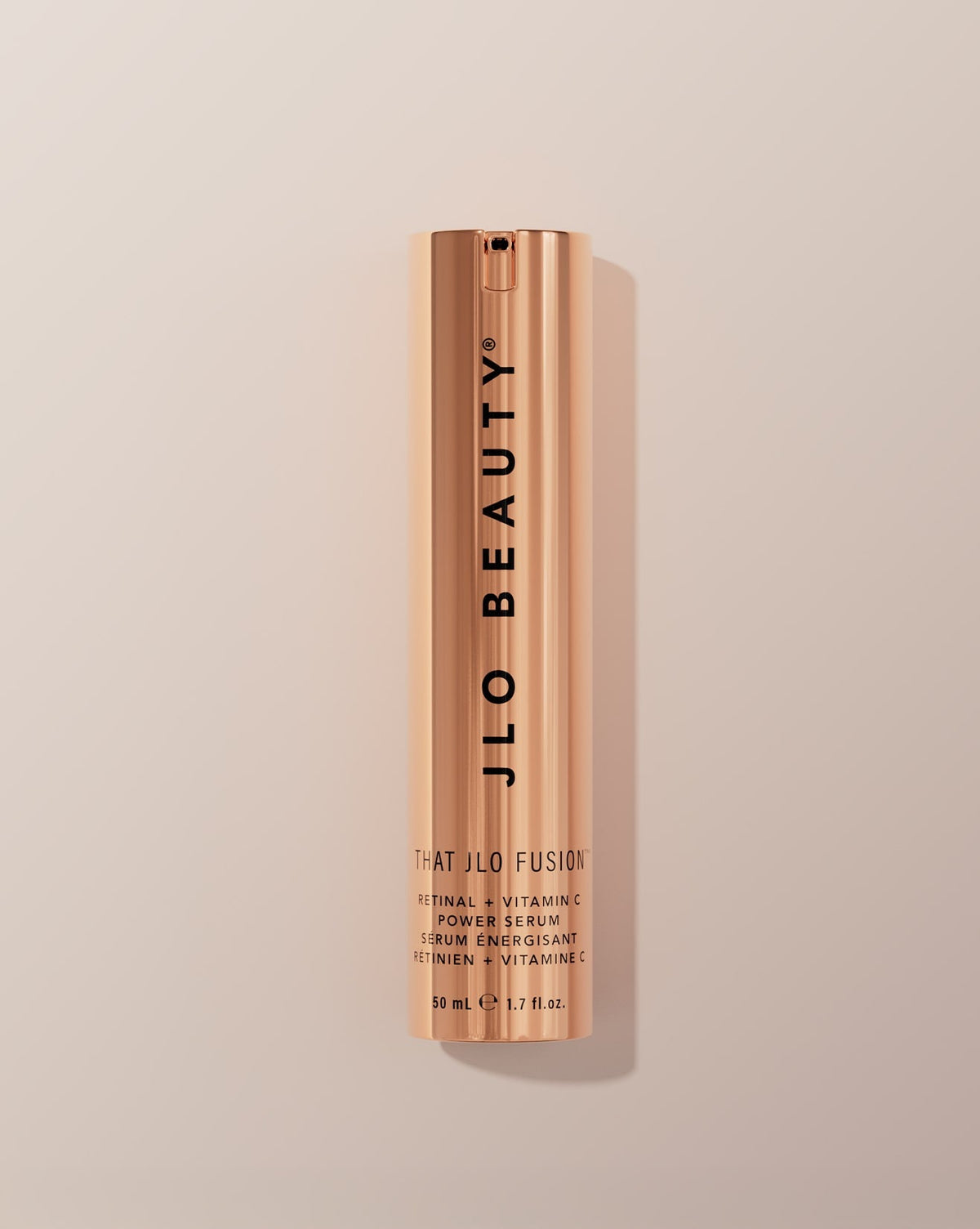JLO Beauty That JLO Fusion Retinal + Vitamin C Power Serum in a sleek, metallic rose gold cylindrical bottle