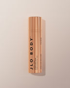 JLO BODY Ultimate Body Serum in a sleek metallic rose gold cylindrical bottle