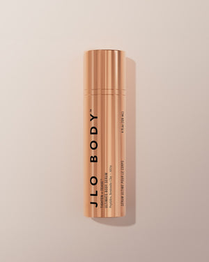 JLO BODY Ultimate Body Serum in a sleek metallic rose gold cylindrical bottle