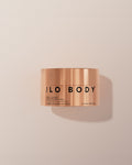 Copper jar of JLO Body balm on a beige background