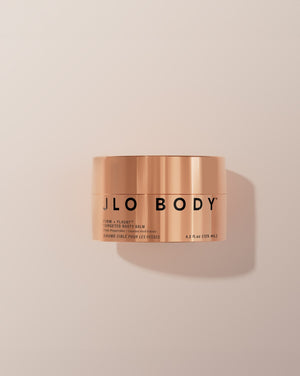 Copper jar of JLO Body balm on a beige background