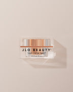 JLO Beauty Eye Cream jar on a neutral background.