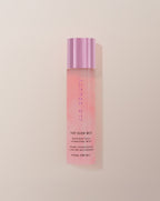 JLO Beauty Glow Mist bottle in soft pink on a neutral background.