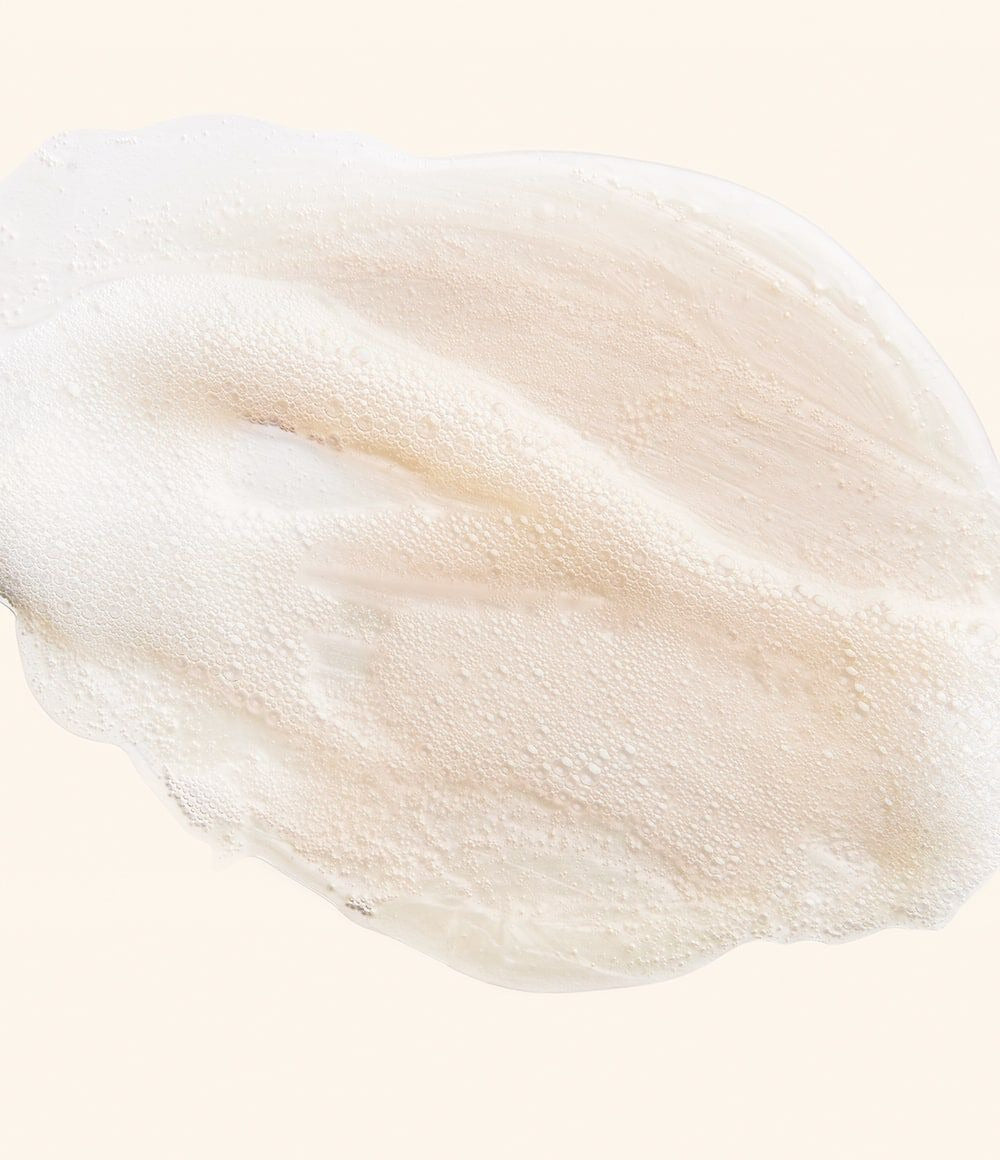 A close-up of a thick, creamy off-white foam.