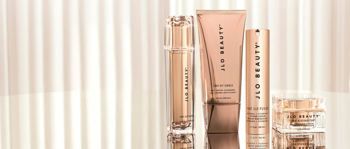 Selection of 4 JLO Beauty products on a cream background. 
